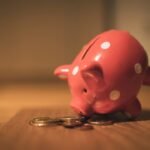 An overturned piggy bank and a few coins